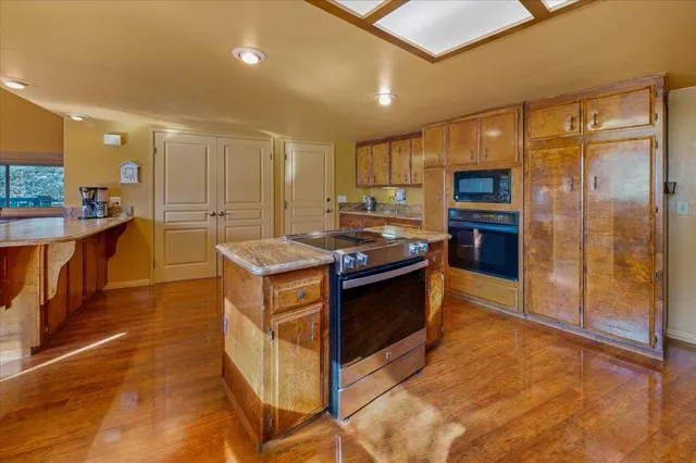 a kitchen with stainless steel appliances kitchen island granite countertop a refrigerator and a stove