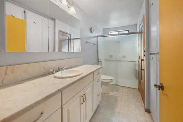 a bathroom with a sink a toilet and shower