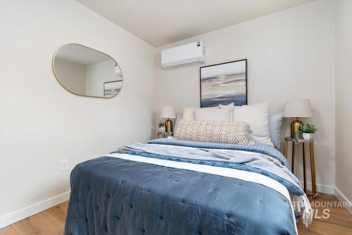3005 West Hester Street Boise, ID 83702 - Photo 25 of 32 Bedroom featuring wood-finish flooring, a wall-mounted climate control unit, and crisp white baseboards