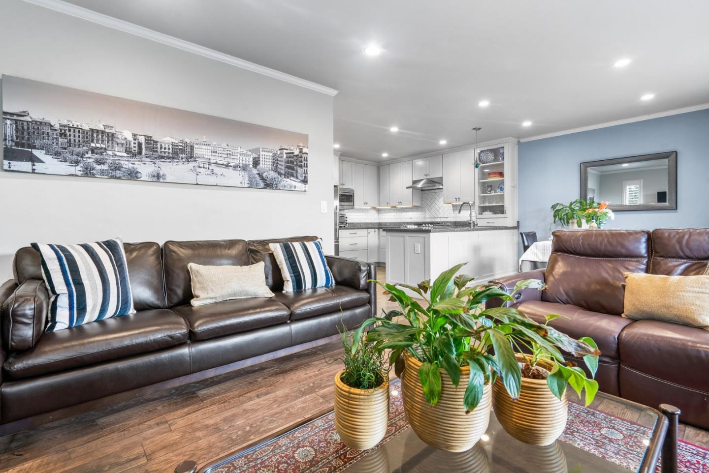 a living room with furniture kitchen and a potted plant
