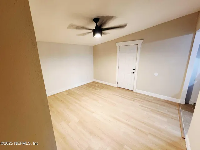a view of empty room with wooden floor