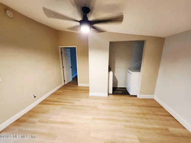 a view of an empty room with wooden floor