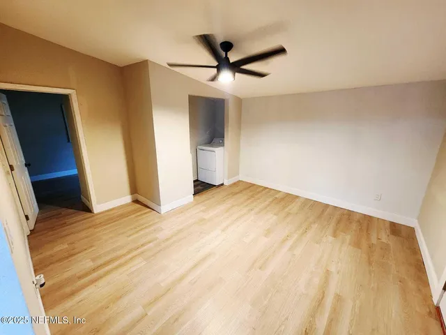 a view of a livingroom with a dishwasher and wooden floor