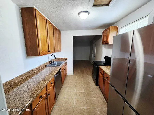 a kitchen with stainless steel appliances granite countertop a refrigerator and a sink