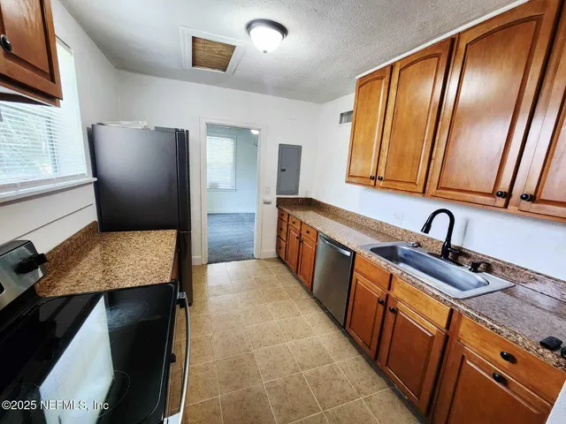 a kitchen with stainless steel appliances granite countertop a refrigerator and a sink