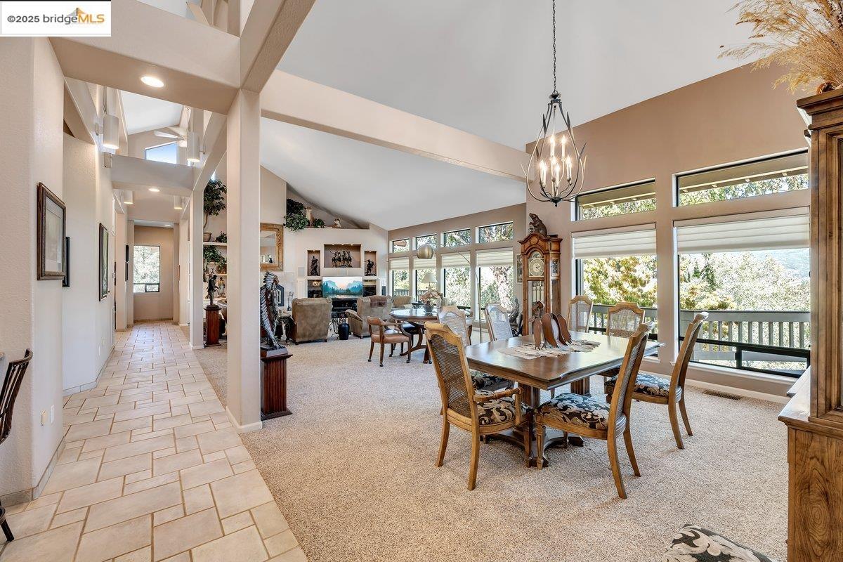 13700 Clements Road Groveland, CA 95321 - Photo 11 of 93 Dining space with high vaulted ceiling, light carpet, healthy amount of natural light, light stone finish flooring, and beam ceiling