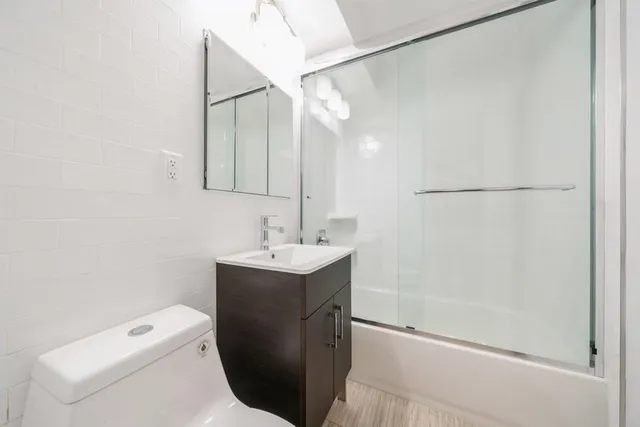 a bathroom with a sink a toilet and shower