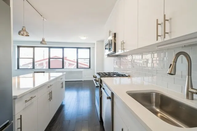 a kitchen with a sink a stove and cabinets