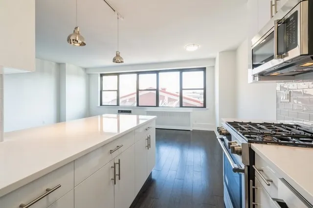a kitchen with granite countertop a stove a sink and a microwave