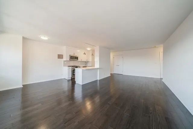 a view of kitchen with wooden floor and electronic appliances