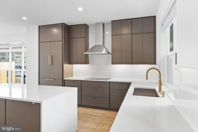 a large kitchen with stainless steel appliances granite countertop a sink a stove and a refrigerator