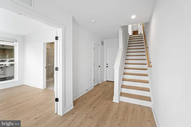 a view of a hallway with wooden floor and entryway