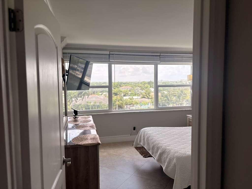 2611 North Riverside Drive, Unit 703 Pompano Beach, FL 33062 - Photo 19 of 81 a bed sitting in a bedroom next to a window