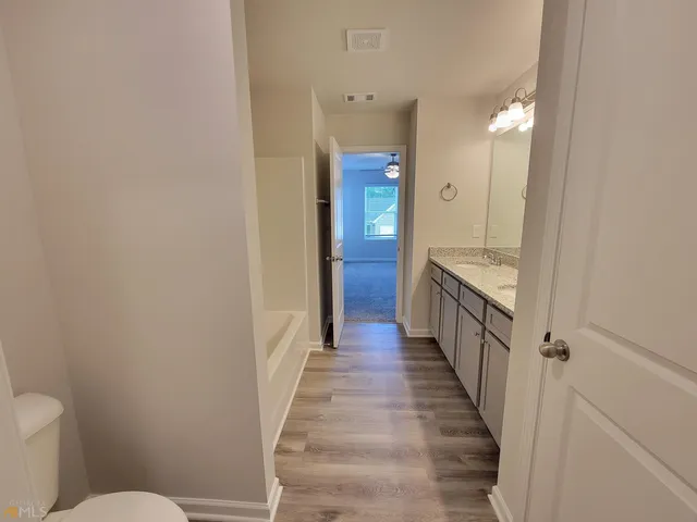 a spacious bathroom with a granite countertop tub sink and mirror