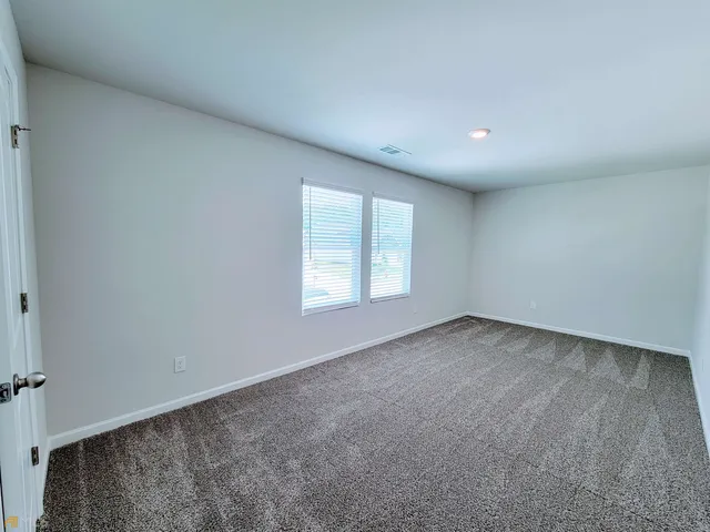 a bathroom with a granite countertop toilet sink and mirror