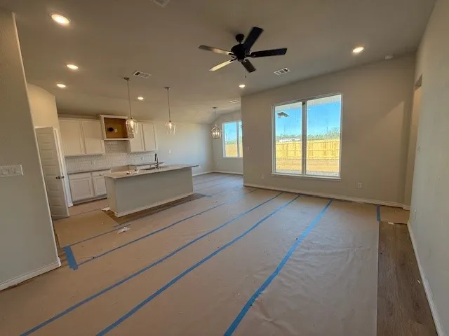 a view of kitchen with cabinets and window