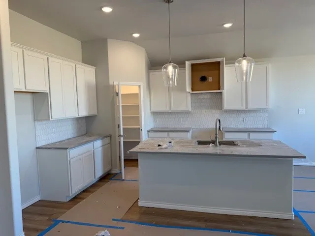 a large kitchen with stainless steel appliances granite countertop a sink a stove and a refrigerator