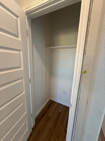 a view of walk in closet with wooden floor