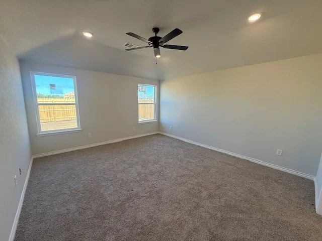 an empty room with a window and a ceiling fan