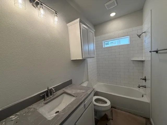 a bathroom with a sink a toilet a mirror and bathtub