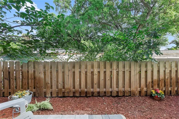 a view of wooden fence with potted plants