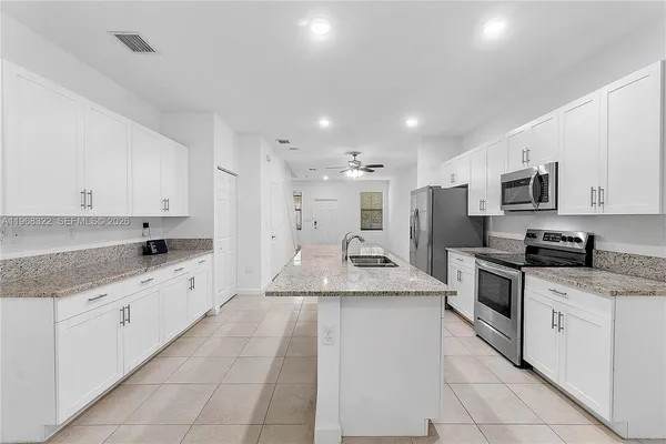 a large kitchen with stainless steel appliances granite countertop a sink and cabinets