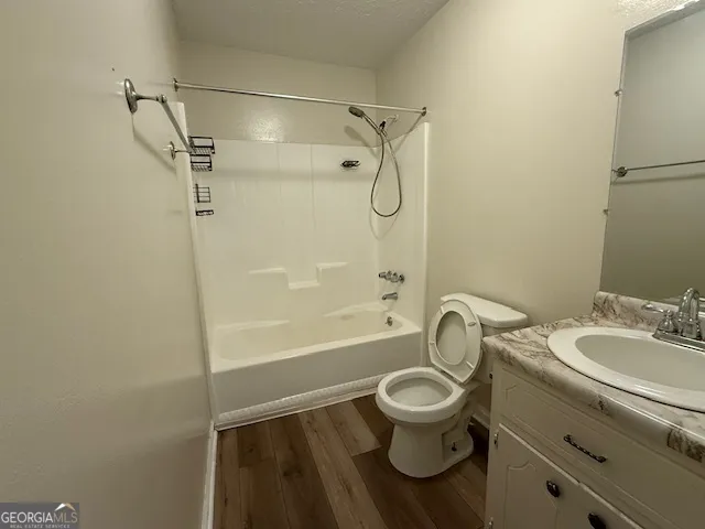 a bathroom with a granite countertop toilet a sink and a bathtub