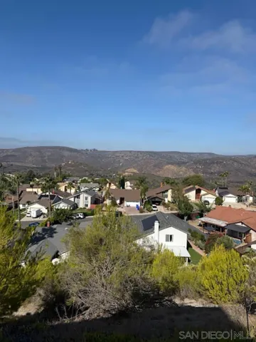 a view of an empty room with wooden floor and fireplace