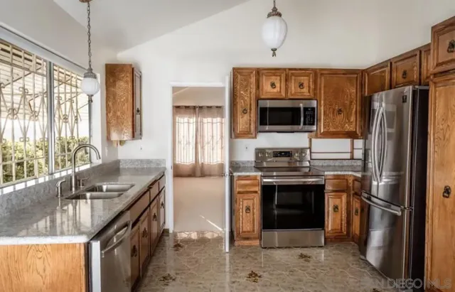 a kitchen with stainless steel appliances granite countertop a stove refrigerator and a sink