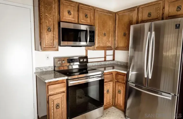 a kitchen with stainless steel appliances granite countertop a refrigerator stove and microwave