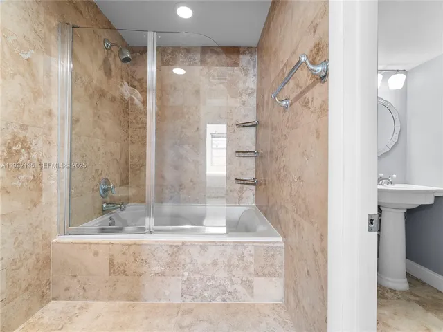 a bathroom with a granite countertop sink a mirror and shower