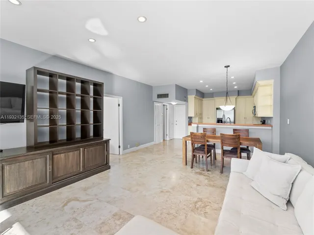 a living room with furniture a dining table and kitchen view