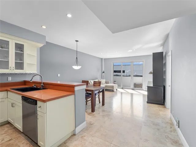 a kitchen with a sink a stove a refrigerator and chairs