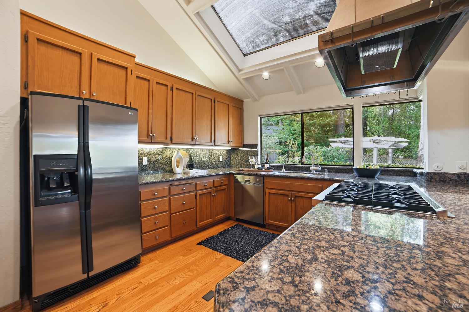 2656 Fir Park Way Santa Rosa, CA 95404 - Photo 14 of 51 a kitchen with stainless steel appliances granite countertop a refrigerator a sink dishwasher a stove and a dining table with wooden floor