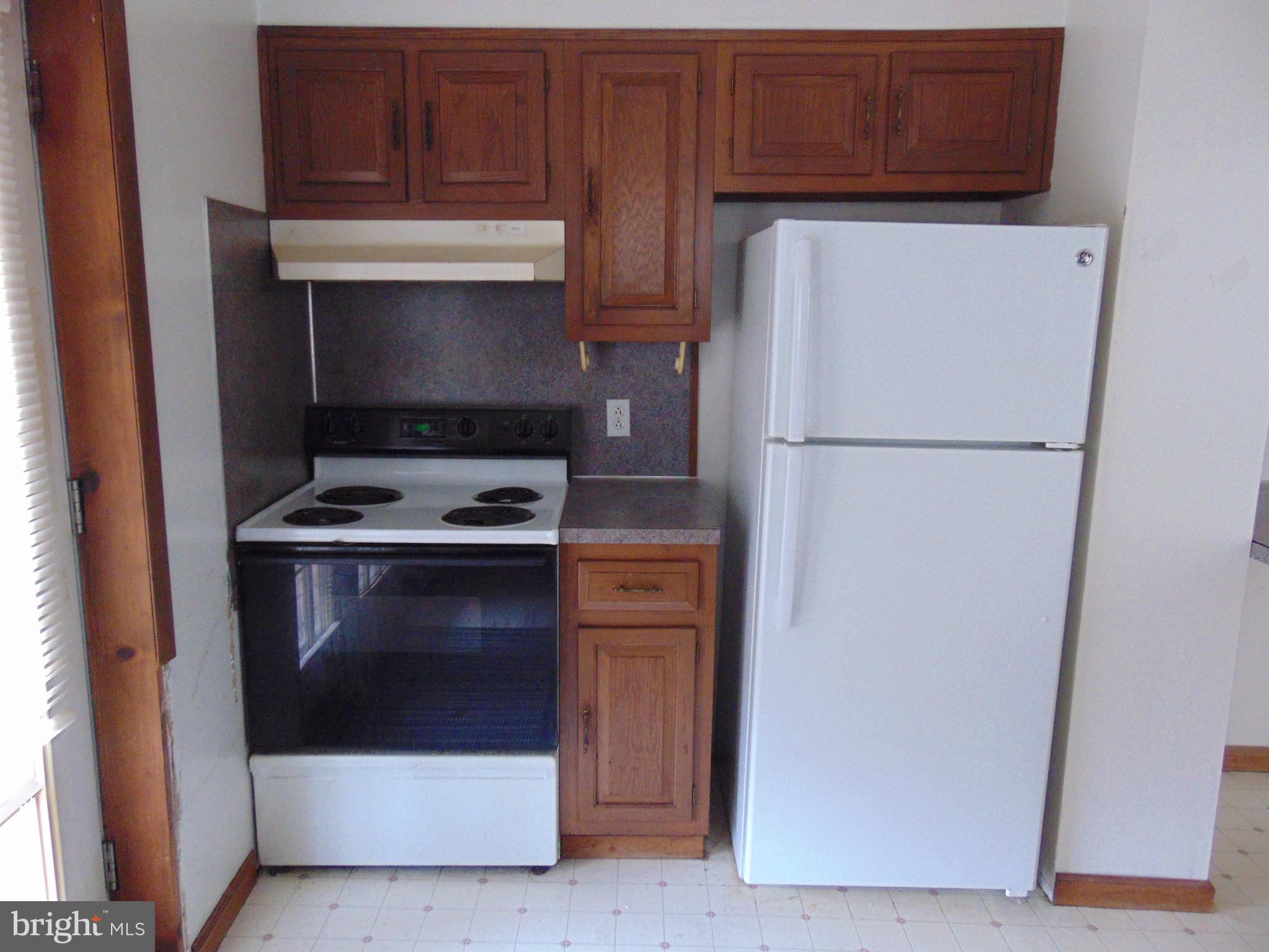 24 East Ridge Street Coaldale, PA 18218 - Photo 29 of 38 a white refrigerator freezer sitting inside of a kitchen with stainless steel appliances wooden cabinet