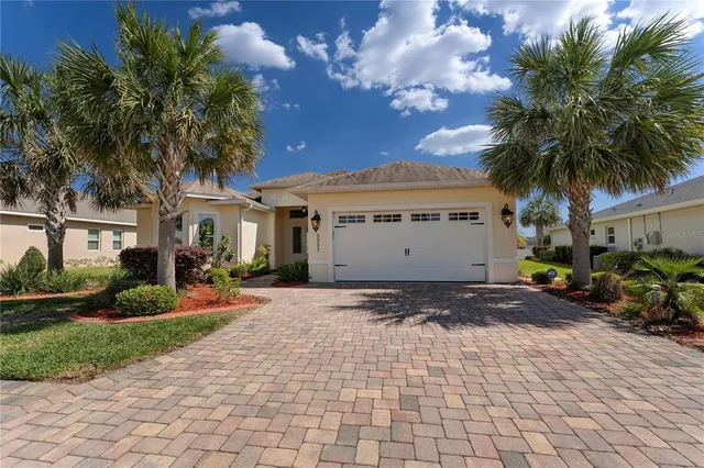 a view of a house with a yard and a garage