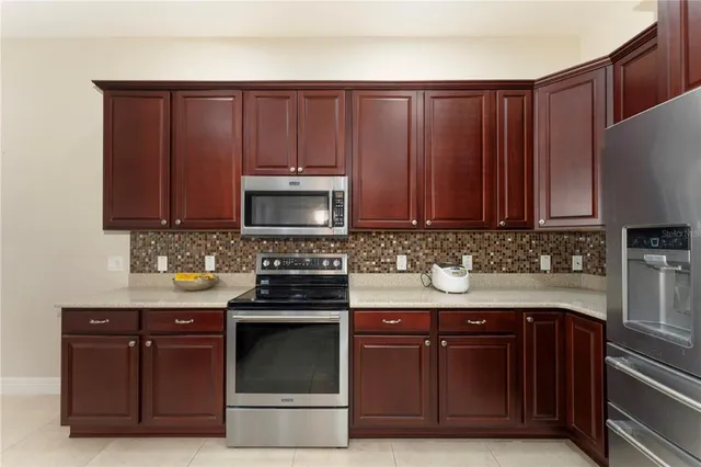 a kitchen with granite countertop wood cabinets and stainless steel appliances
