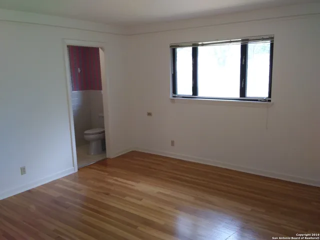 a view of a hallway with wooden floor and chandelier