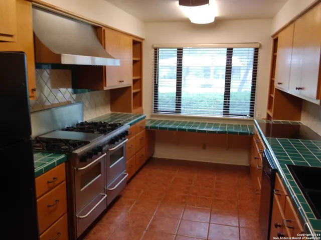 a kitchen with stainless steel appliances granite countertop a stove and a sink