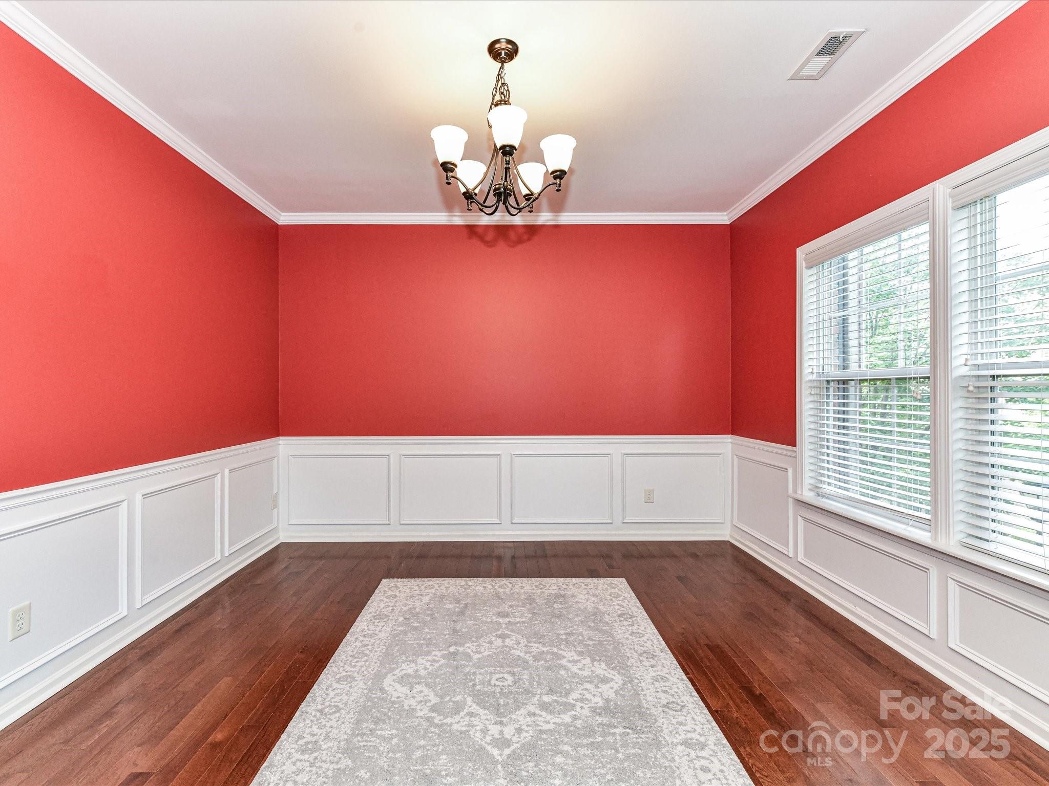 756 Naramore Street Davidson, NC 28036 - Photo 12 of 46 a room with a chandelier and wooden floor