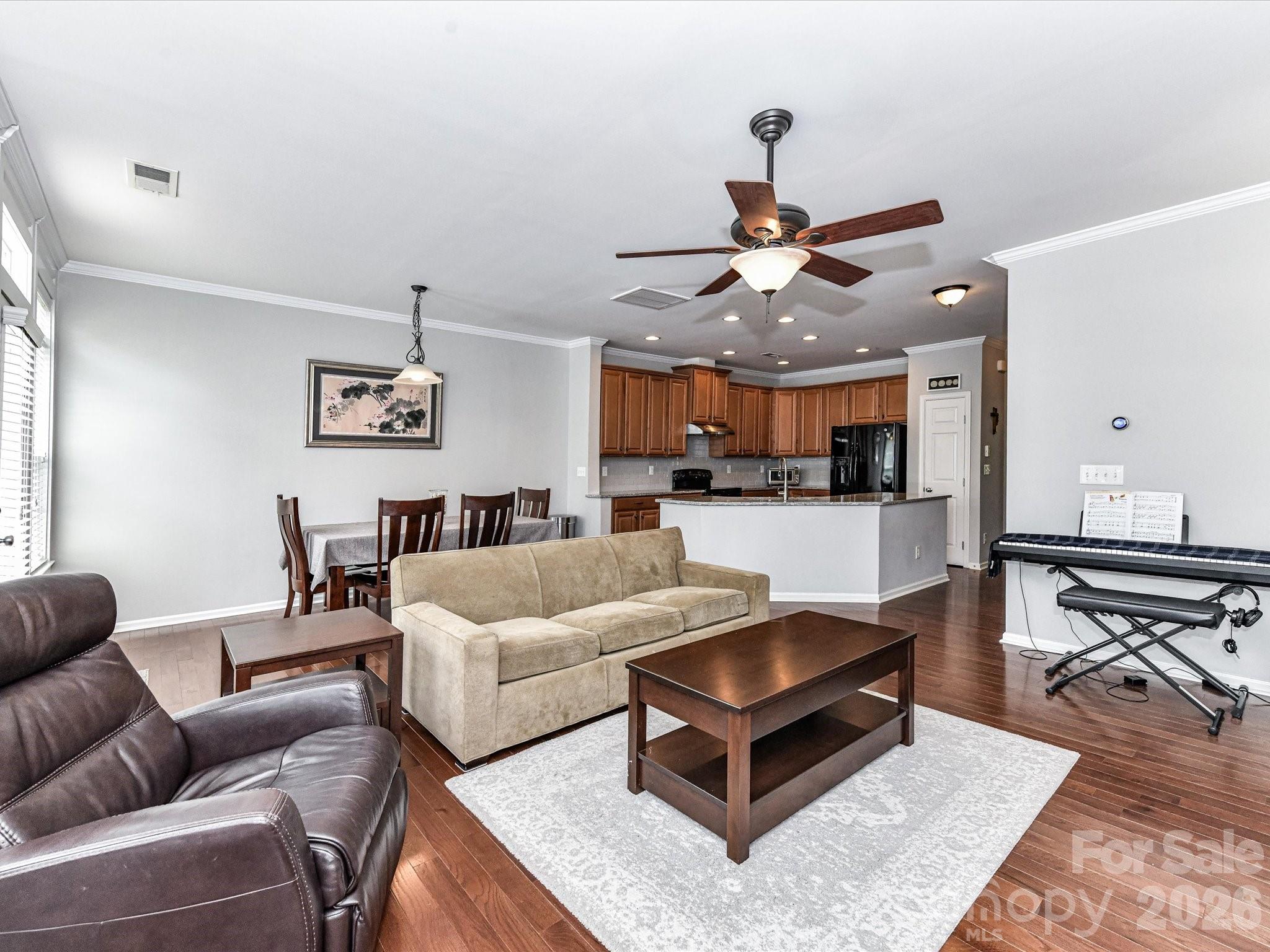 756 Naramore Street Davidson, NC 28036 - Photo 17 of 44 a living room with furniture a kitchen view and a chandelier