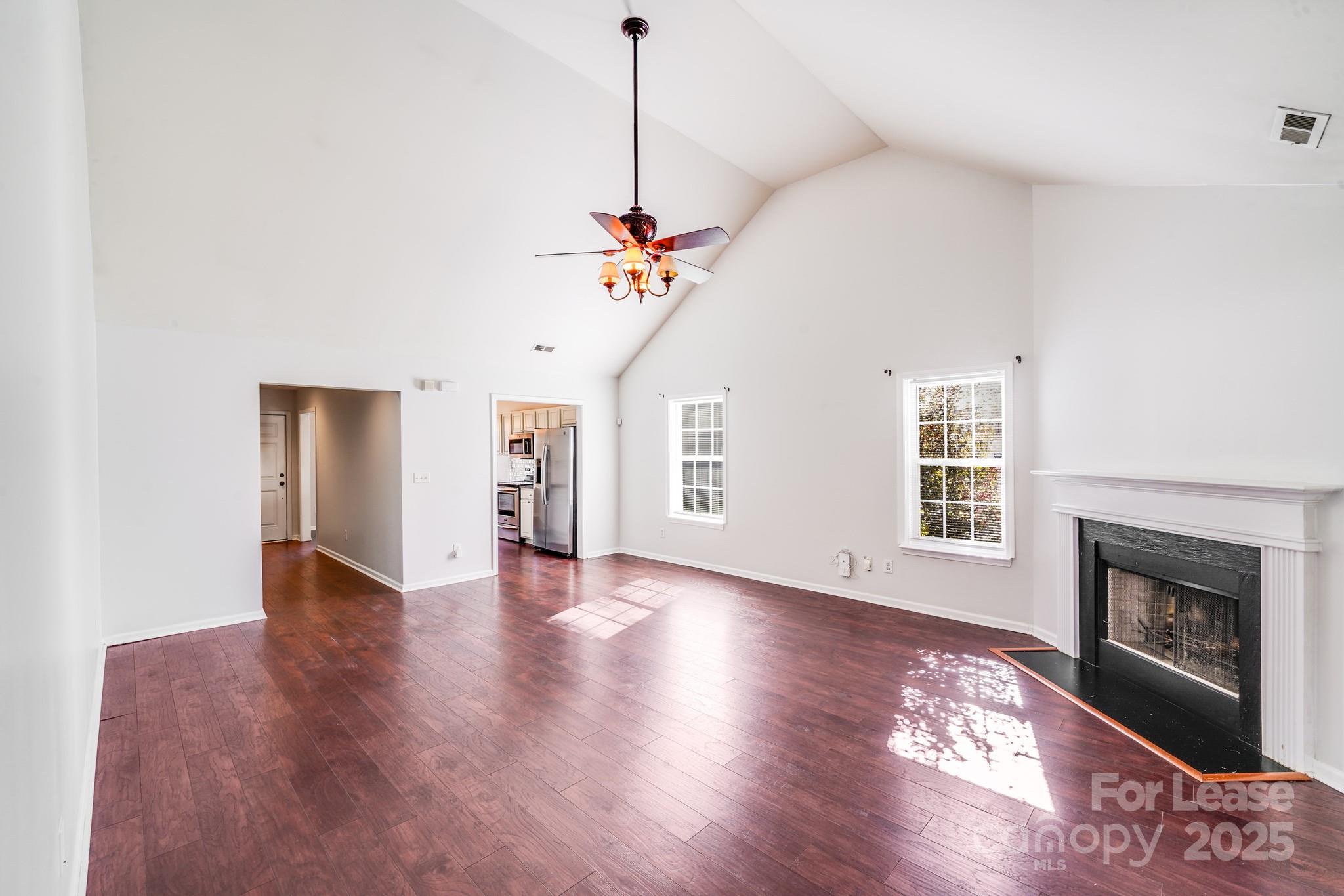 1427 Jabbok Place Northwest Concord, NC 28027 - Photo 12 of 30 a view of an empty room with a fireplace and wooden floor