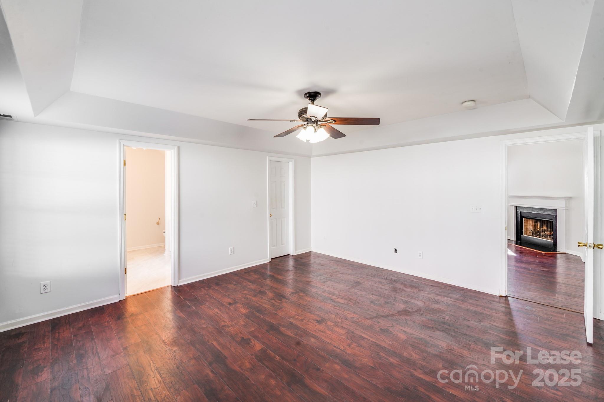 1427 Jabbok Place Northwest Concord, NC 28027 - Photo 18 of 30 an empty room with wooden floor and chandelier fan