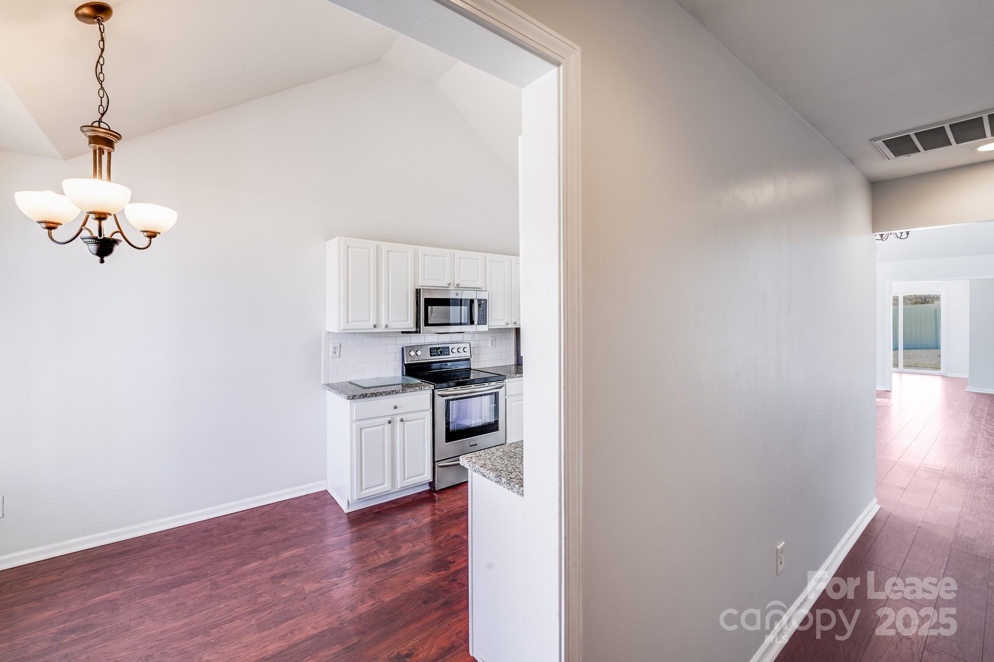 1427 Jabbok Place Northwest Concord, NC 28027 - Photo 7 of 30 a kitchen with a refrigerator and a stove top oven