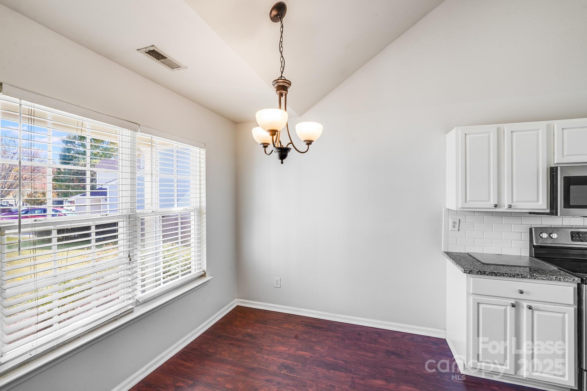 1427 Jabbok Place Northwest Concord, NC 28027 - Photo 8 of 30 a kitchen with stainless steel appliances granite countertop a sink dishwasher a refrigerator and a stove with wooden floor