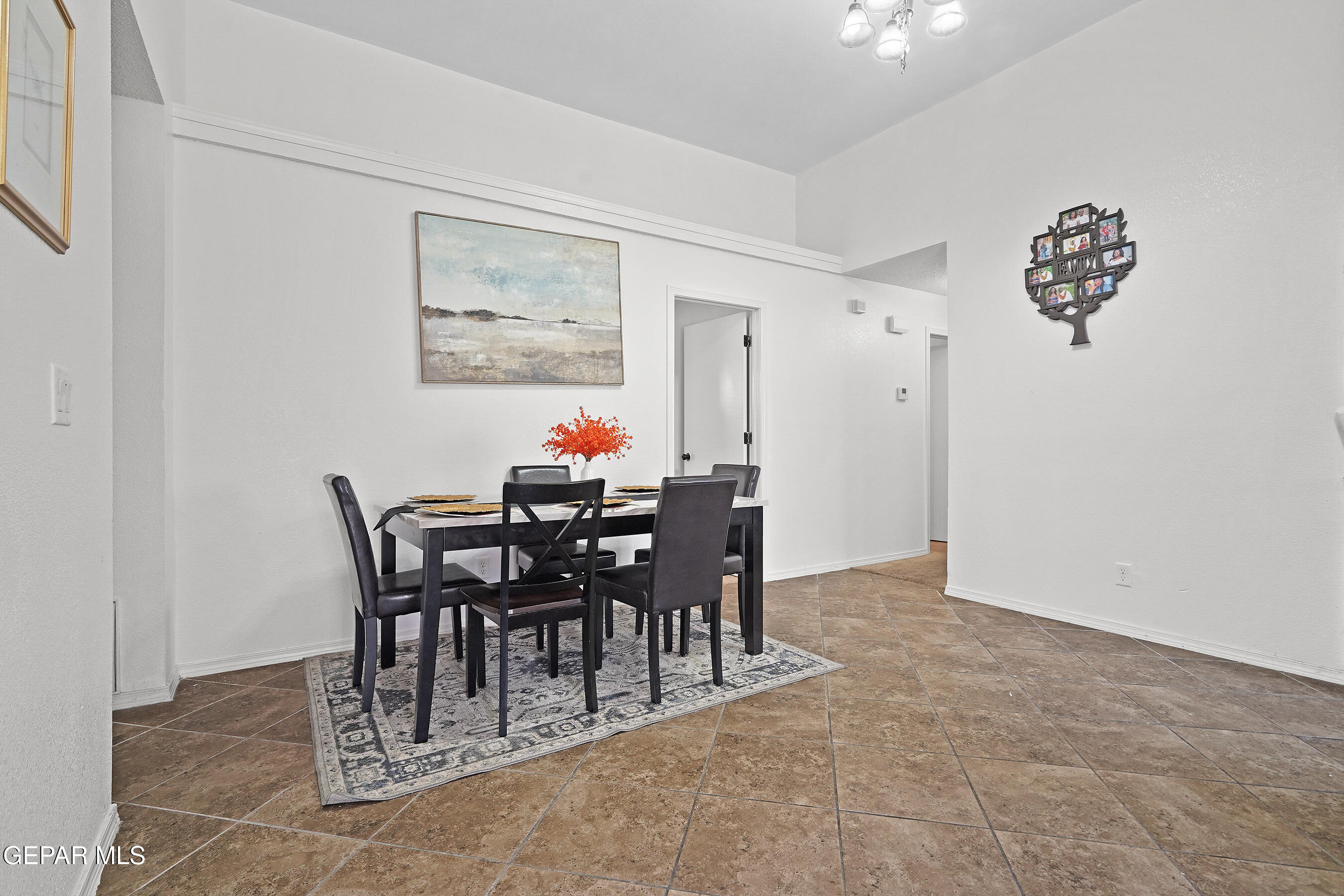 12733 Raul Mendiola Lane El Paso, TX 79938 - Photo 19 of 30 a view of a dining room and kitchen with furniture and a chandelier