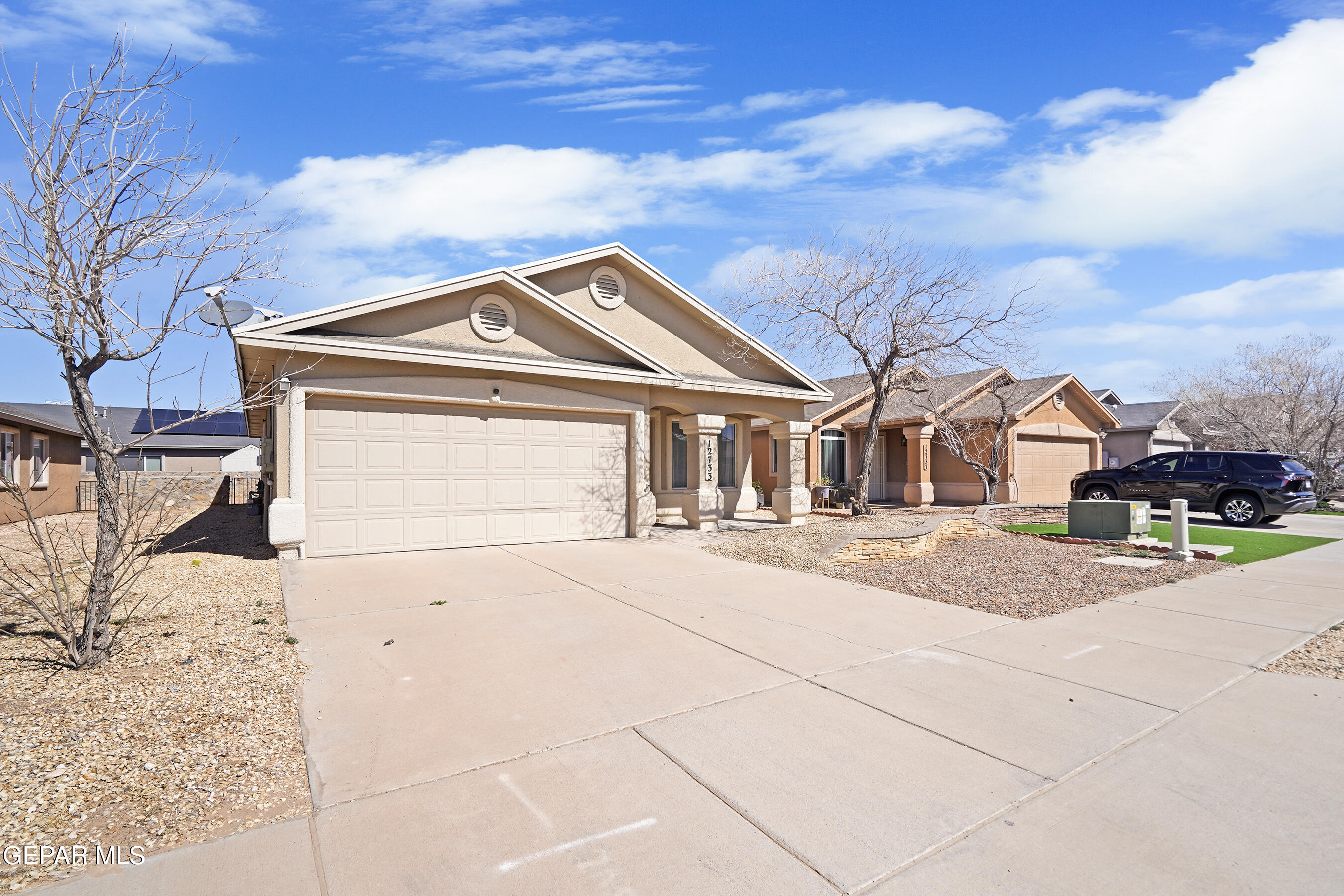 12733 Raul Mendiola Lane El Paso, TX 79938 - Photo 2 of 30 a front view of a house with a yard and garage
