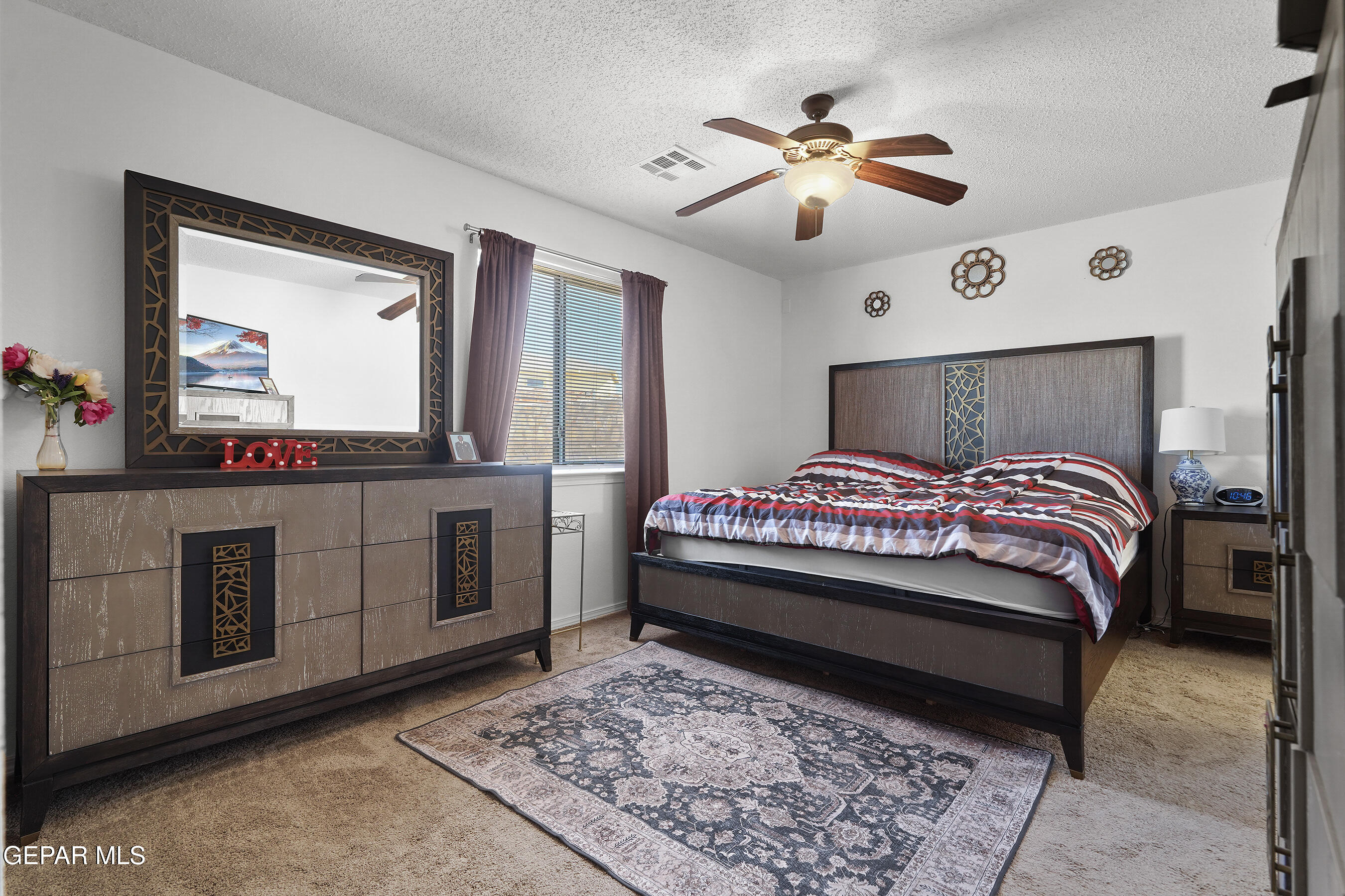 12733 Raul Mendiola Lane El Paso, TX 79938 - Photo 22 of 30 a bedroom with a large bed and a chandelier