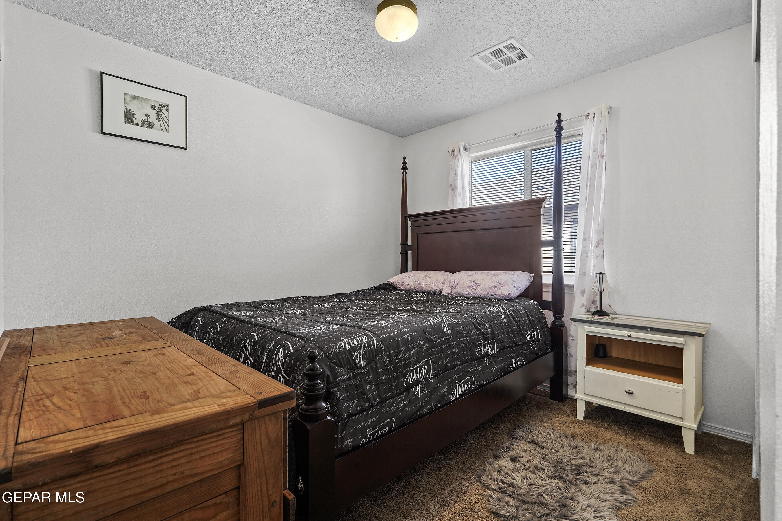 12733 Raul Mendiola Lane El Paso, TX 79938 - Photo 5 of 30 a bedroom with a bed and a lamp on the dresser