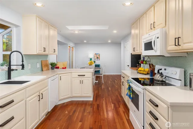 a kitchen that has a lot of cabinets in it and wooden floors